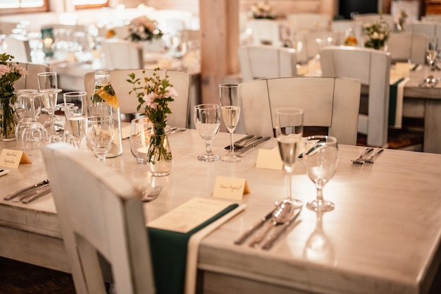 Prado decorado para cerimônia de casamento Banquete de casamento As cadeiras e mesa redonda para convidados servidos com flores de talheres