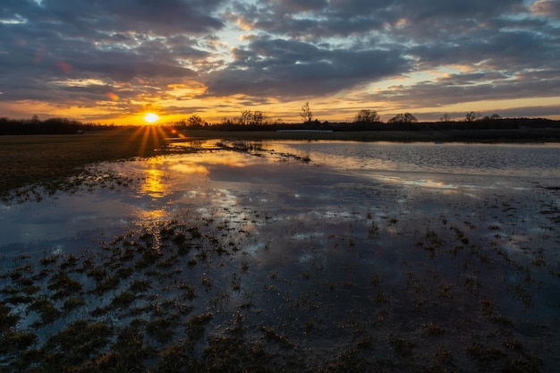 Foto prado inundado após nuvens de chuva e pôr do sol nowiny polônia