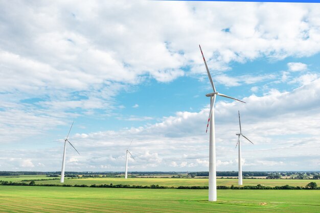 Prado verde con turbinas eólicas que generan electricidad, paisaje de verano con cielo azul, fuentes de energía alternativas