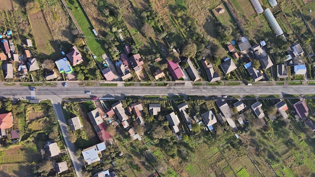 Prados agrícolas do final do outono ao redor da vila nas casas em primeiro plano e estrada um campo após a colheita