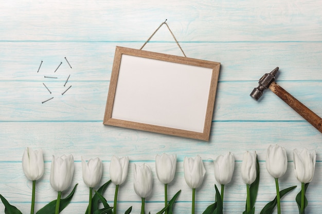Prados brancos das tulipas, da placa de giz, do martelo e do metal em placas azuis. Dia das Mães
