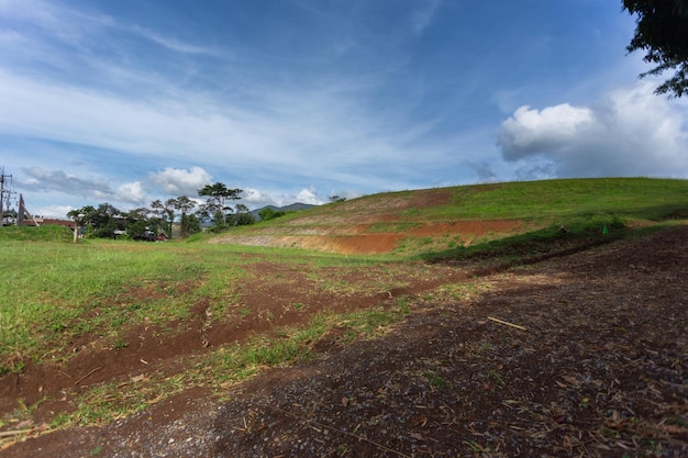 Prados verdes com fundo de céu azul e nuvens