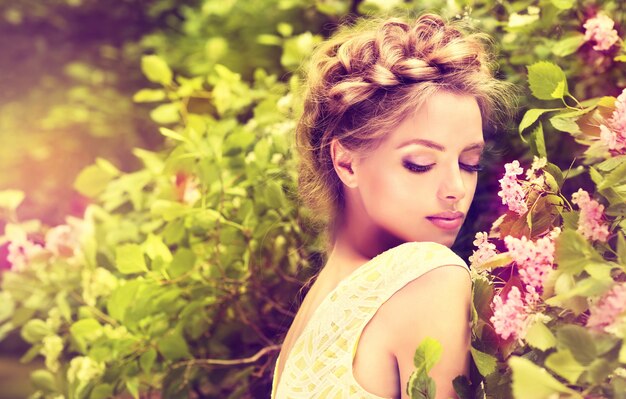 Prächtige junge Frau, umgeben von blühenden Blumenbäumen.