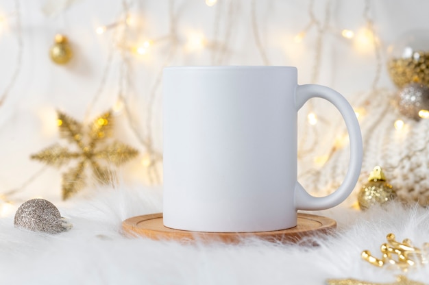 Prägen Sie weiße Keramikkaffeetasse des Modells auf gemütlichem Weihnachtshintergrund mit Kopienraum für Ihr Design ein