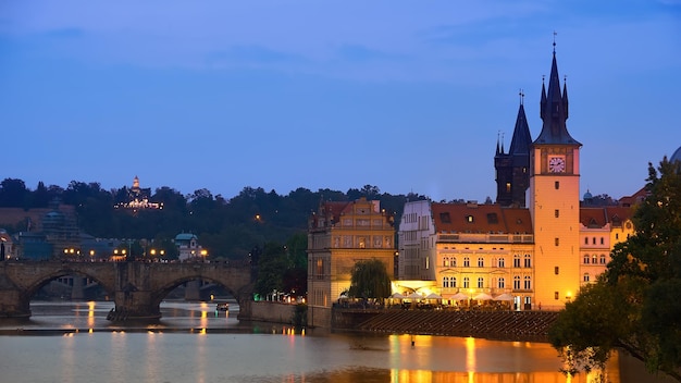 Prag am Flussufer am Abend Karlsbrücke und Novotnevo Lavka mit Uhrturm