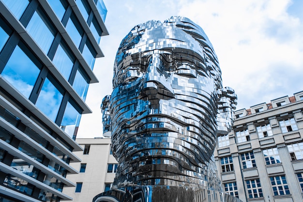 Praga / Checa - 21.05.2019: cabeza del monumento en movimiento Franz Kafka en el centro de Praga. Objeto de arte cromado brillante escultura de 64 placas.