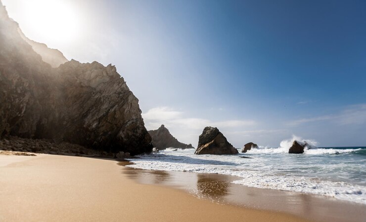 Foto praia bonita isolada no sol da tarde rochas e ondas oceano atlântico praia da ursa portugal