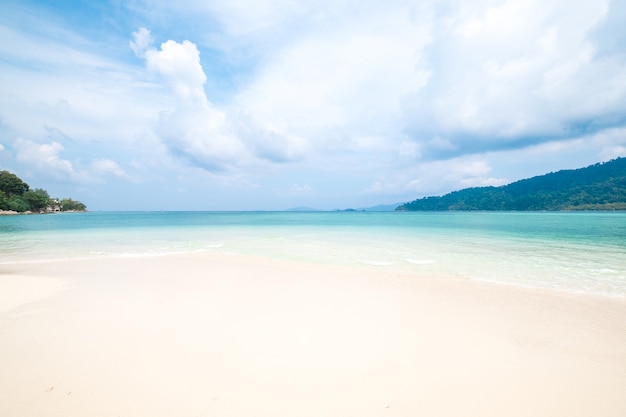 Praia branca bonita da areia com a onda de oceano macia nas horas de verão, curso do conceito.