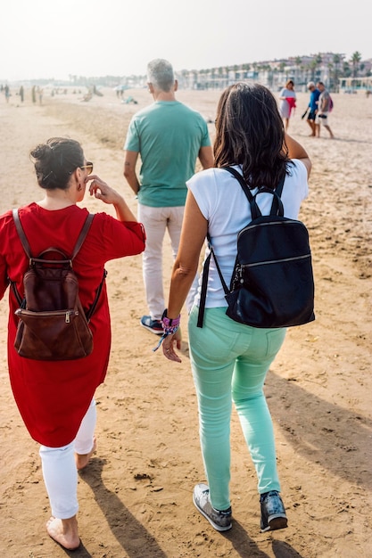 Praia cheia de turistas na zona hoteleira durante o pôr do sol