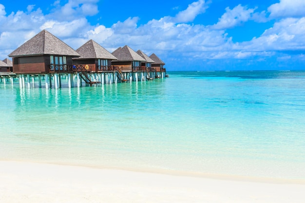 Praia com bangalôs aquáticos em MaldivesxAxA