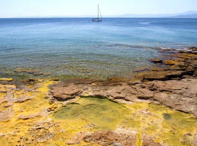 Praia com fontes termais e veranistas no Greek Spa resort na ilha grega