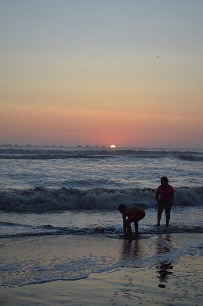 Praia com mar e cais e gente