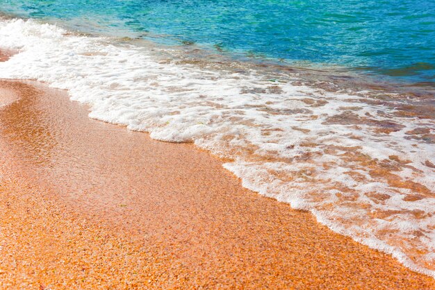Praia com um lindo mar ondulado, férias de verão