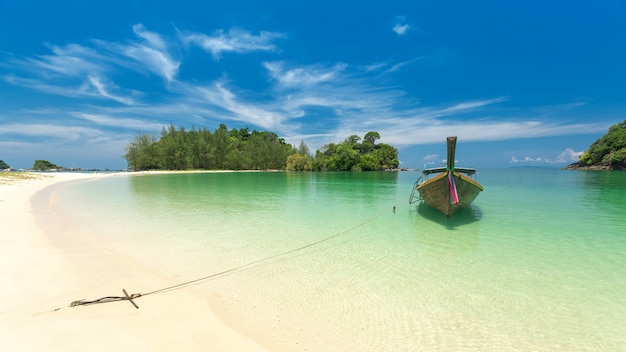 Praia da areia e barco brancos da Longo-cauda na ilha de Kham-Tok (koh-kam-tok), Tailândia.