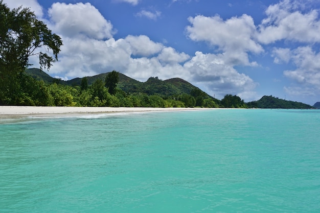 praia de areia branca com água turquesa e céu azul com nuvens, Oceano Índico, Ilha de Praslin, Seychelles, África