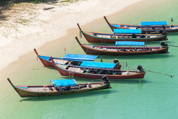 Praia de areia branca e barco de cauda longa na ilha de Kham-Tok (koh-kam-tok