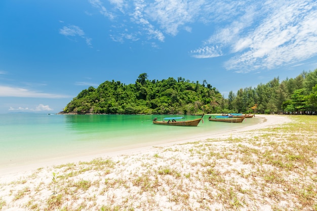 Praia de areia branca e barco de cauda longa na ilha de kham-tok (koh-kam-tok