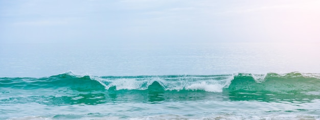 Praia de areia branca e ondas de azul suave