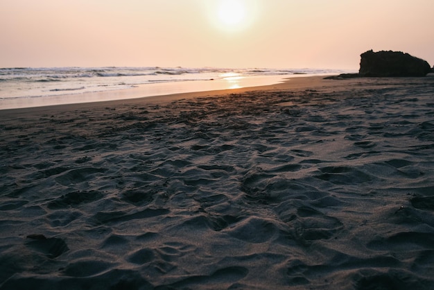 Praia de areia com céu ao pôr-do-sol