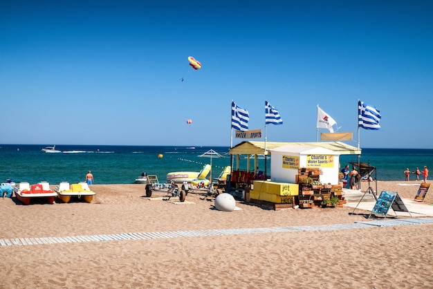 Praia de areia com desportos aquáticos no resort Faliraki na ilha Grécia de Rodes