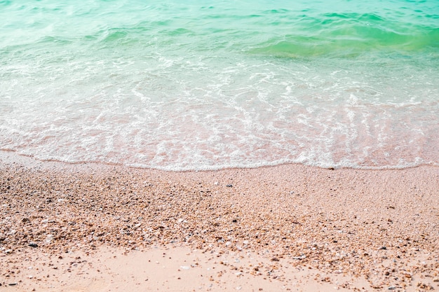 Praia de areia com mar azul-turquesa.