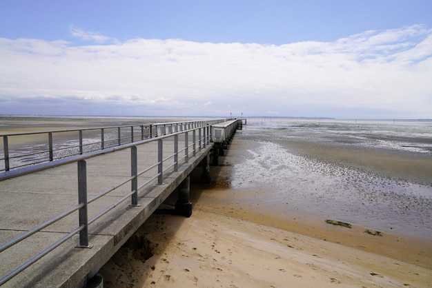 Praia de areia de Andernos na maré baixa com pontão Pier