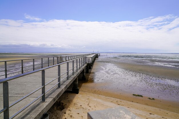 Praia de areia de Andernos na maré baixa vista do cais em dia ensolarado de verão