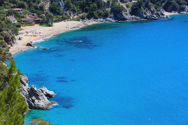 Praia de areia do mar de verão. Litoral entre Barcelona e Palamos (Costa Brava, Catalunha, Espanha). As pessoas estão irreconhecíveis.