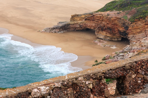 Praia de areia do oceano perto da cidade de Nazaré (Portugal).