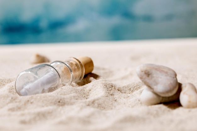 Praia de areia e mar de verão com ondas e garrafa de vidro com mensagem