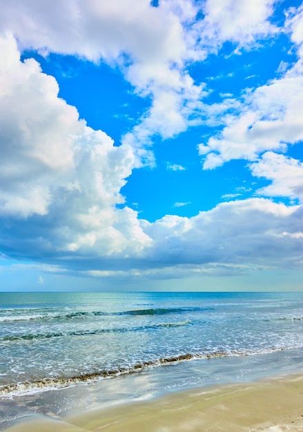 Praia de areia e nuvens brancas no céu