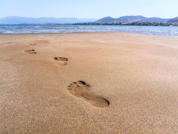 Praia de areia e pegadas na areia na maré baixa na praia de Liani Ammos em Halkida Grécia