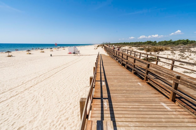 Praia de areia larga com pontes de madeira ao longo das dunas em Monte Gordo Algarve Portugal