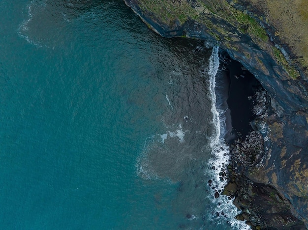 Praia de areia preta da Islândia com ondas enormes em reynisfjara vik