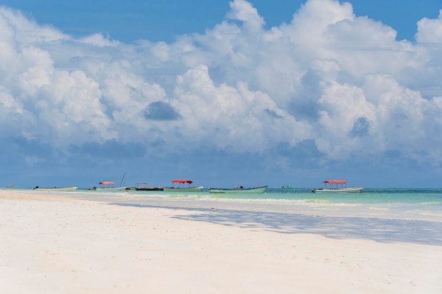 Praia de areia tropical água do mar e céu azul com nuvens brancas na ilha de Zanzibar Tanzânia África