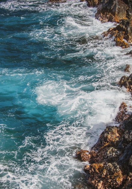 Praia de areia vermelha em Maui em ondas do mar havaiano e fundo de praia rochosa de verão