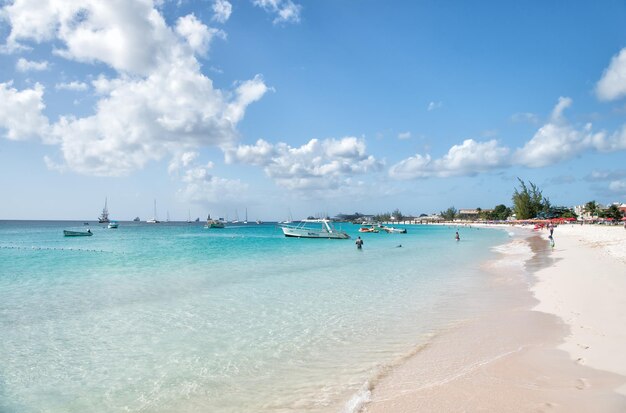 Praia de Barbados com barcos e pessoas