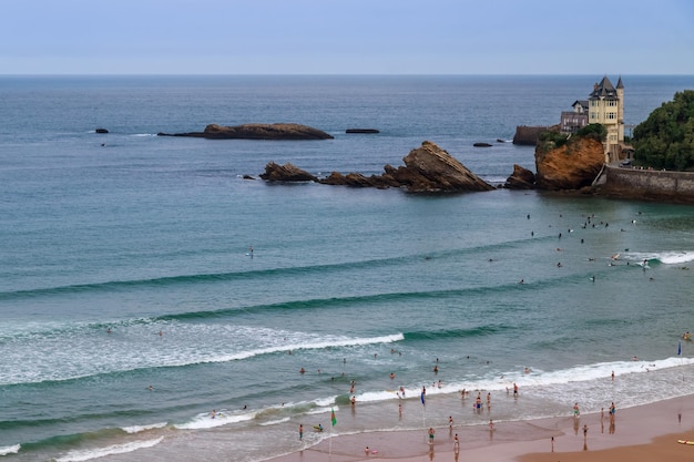 Praia de férias ativas de Biarritz França com surfistas e litoral rochoso cênico com marco icônico