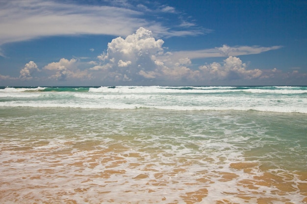 Praia de Habaraduwa, ao sul do Sri Lanka. Oceano ondulado e céu nublado