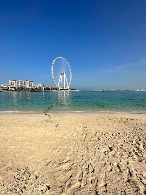 Foto praia de jumeirah, em dubai, em frente à roda gigante