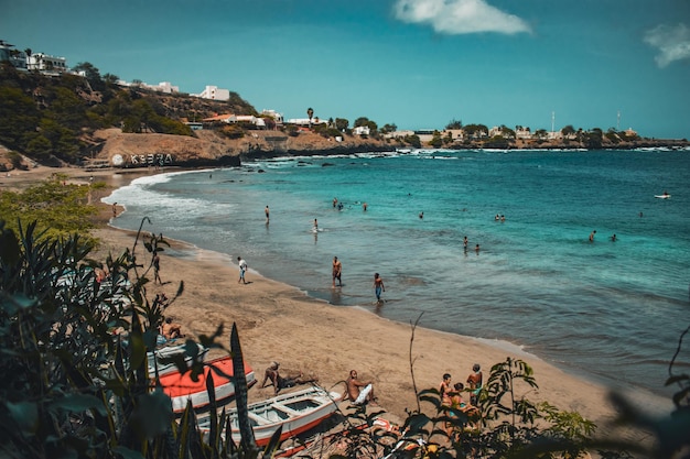 Praia de Kebra Canela. Uma das principais praias de Santiago, com gente nela e barcos ao lado.