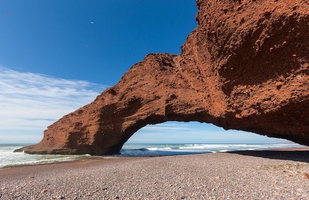 Praia de Legzira com rocha arqueada em Marrocos