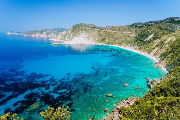 Praia de Myrtos com água do mar azul-celeste na baía Turista favorito que visita o local de destino