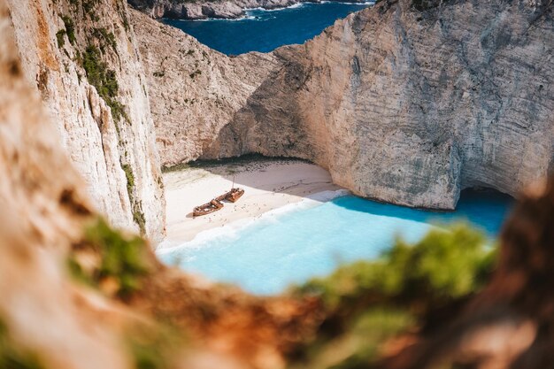 Praia de Navagio ou baía de naufrágios Água do mar turquesa e praia branca entre enormes falésias rochosas famosas