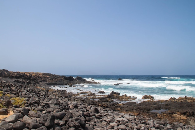 Praia de pedras grandes pretas nas Ilhas Canárias de Lanzarote