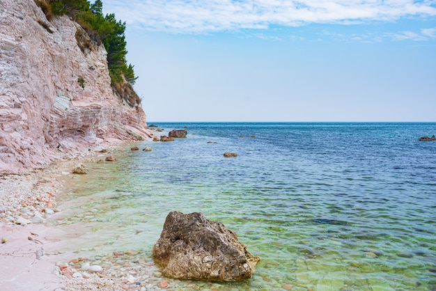 Foto praia de seixos baía colorida no parque natural de conero dramática costa promontório rocha penhasco mar adriático destino turístico itália turquesa águas transparentes