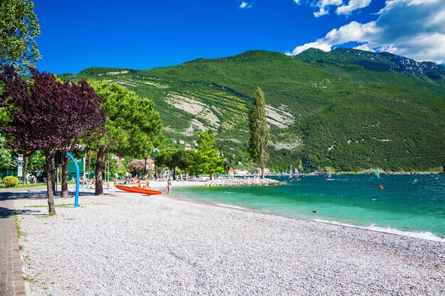 Praia de seixos na pequena aldeia de Torbole no lago Garda, Trentino, Itália