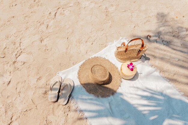 Foto praia de verão pano branco na areia com chapéu de palha de coco e saco