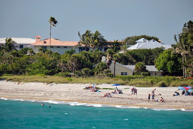 Praia do resort com areia branca azul oceano água linha de confortáveis casas de hotel sob o sol tropical azul