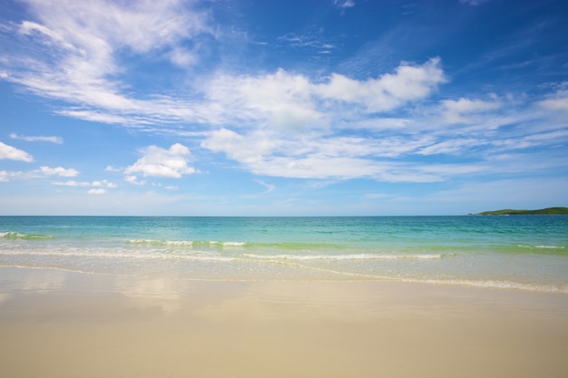 Praia e mar tropical sob o céu azul brilhante no dia de verão